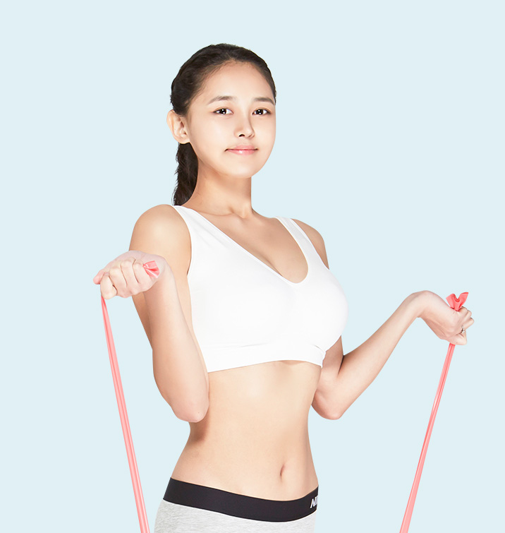 Triple Impact Liposuction (Water Jet, Power Liposuction and Acculift): woman in a white sports top holding a pink resistance band (advertising model)